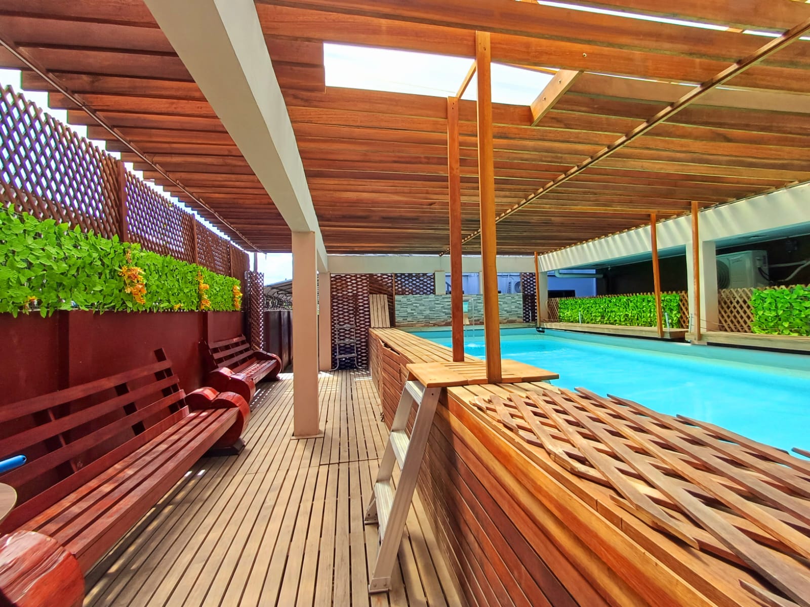 Zwembad en houten terras van Coral Palm Suites in avondlicht